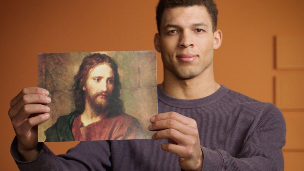 Un uomo che regge un’immagine di Gesù Cristo