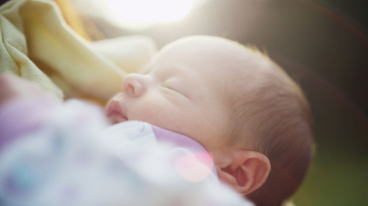 Un padre tiene in braccio una bimba appena nata