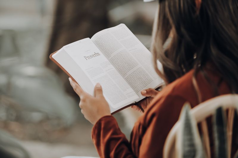 Una donna legge il libro dei Proverbi nella Bibbia
