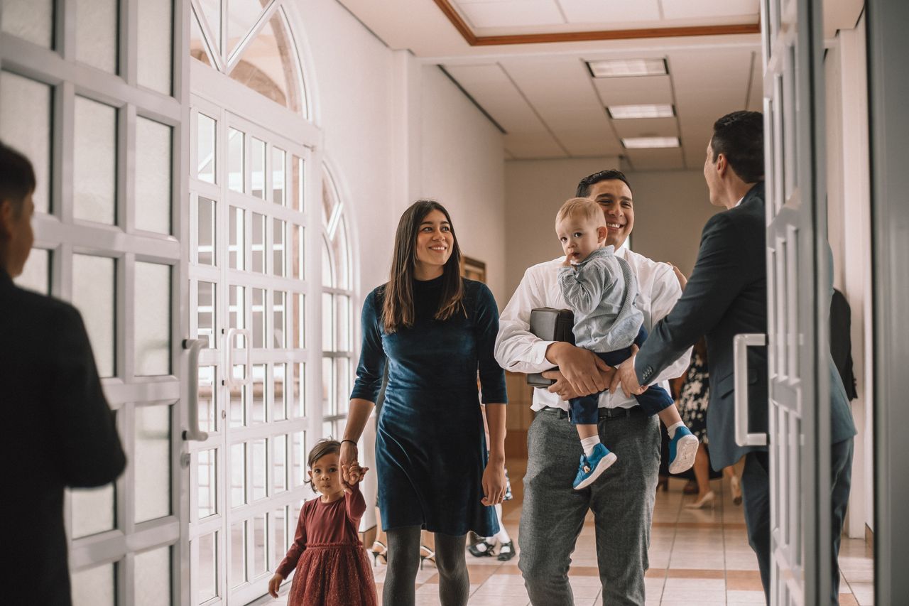Una giovane famiglia entra in chiesa per scoprire di più sul vangelo di Gesù Cristo